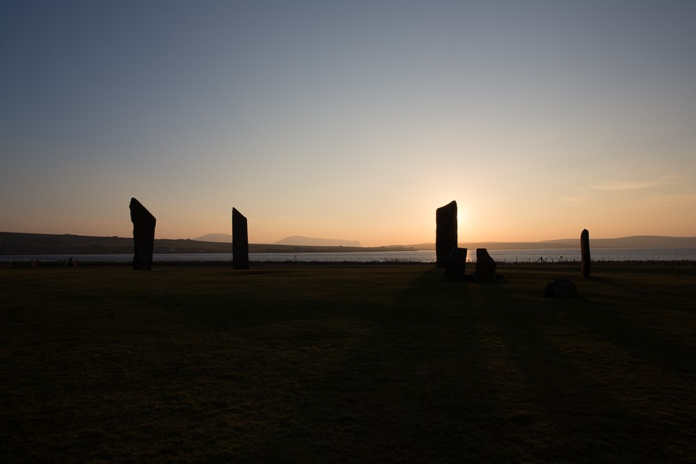 Standing stones silhouetted against the sunrise or sunset.