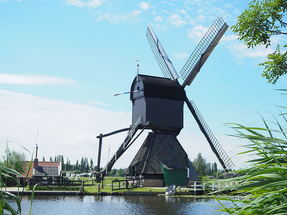 A hollow post mill, seen from the side. It looks like a house sitting on top of another house.