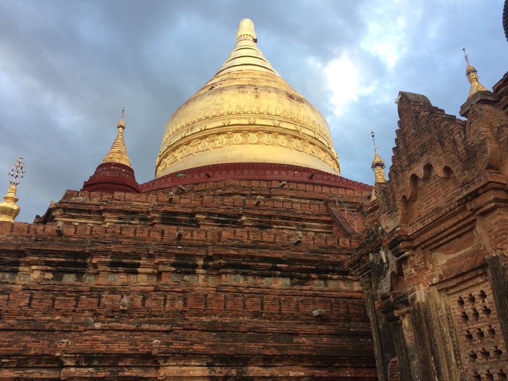 A large brick temple with a round white stupa on the top at Bagan, Myanmar.