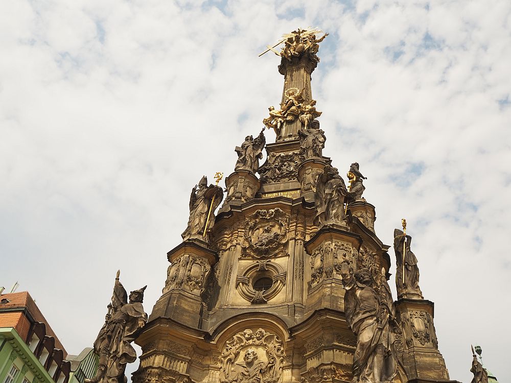 The lower, wider part of the column is shown here, busy with many statues of saints, mostly clutching rods or crosses of gold, and reliefs between them.