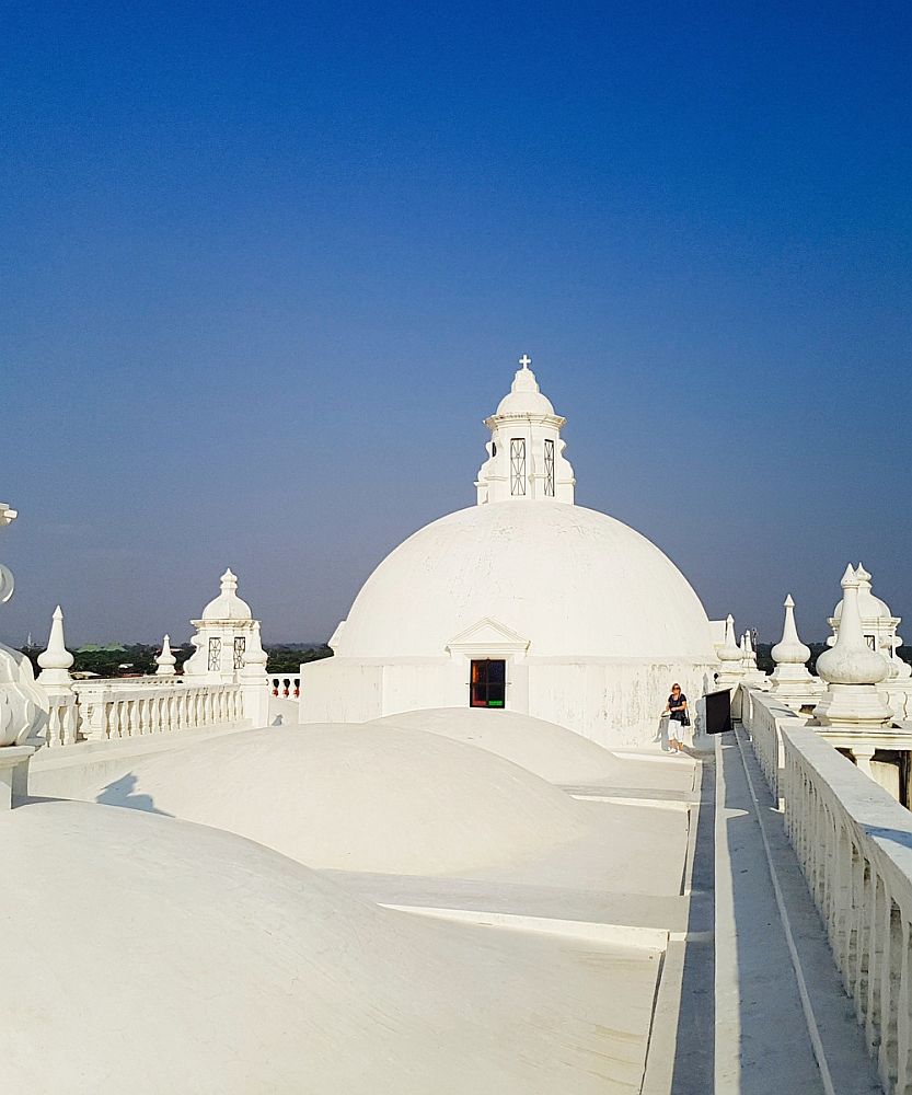 A view of the roof of Leon Cathedral. In a row, 3 smooth white low domes like small hills. Beyond them, a proper architectural dome, also white, with a little cupola on top.