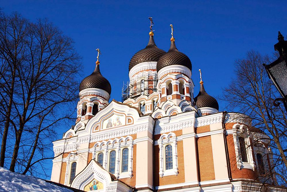 Russian Orthodox church: orangy-red in color, with white trim. Several onion domes of various sizes emerge from the top, with a cross on the top of each.
