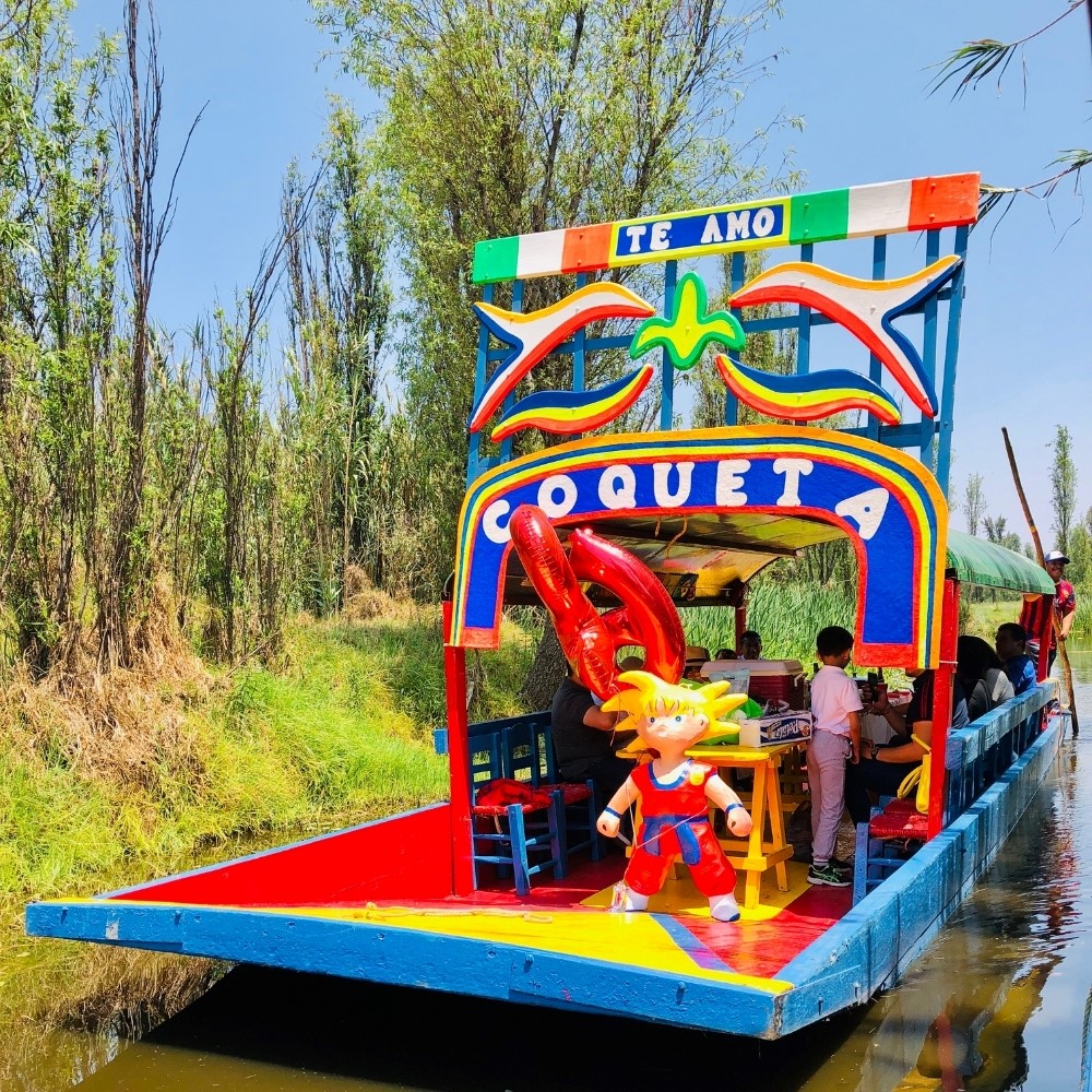 A barge with a flat bottom, painted in bright colors with the words "Te amo" and "Coqueta".