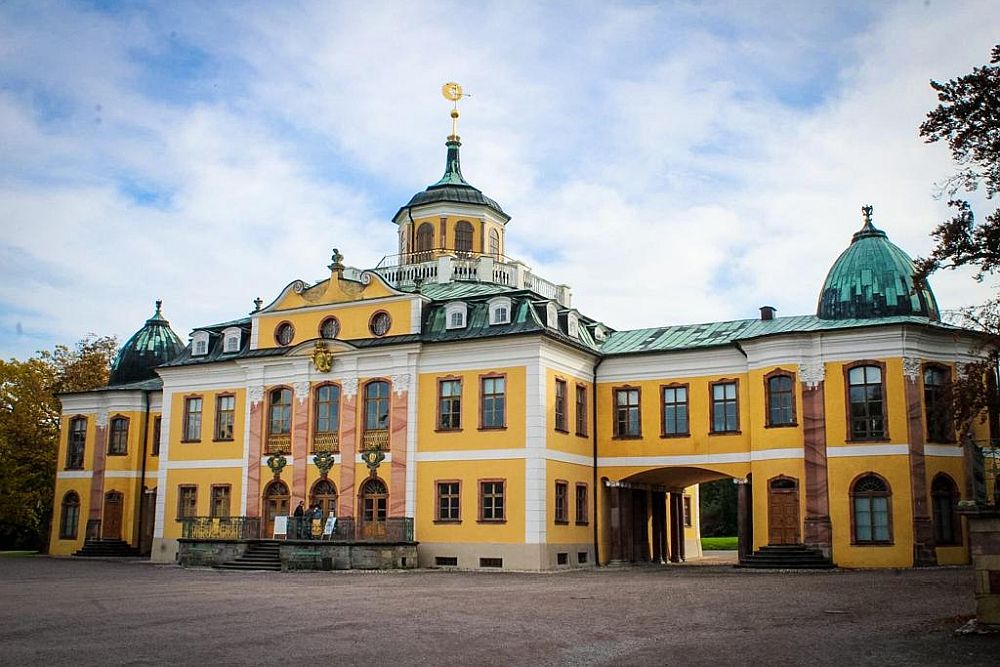 A palace: not huge, but elegant. Two stories, plus another under the roof, which has a small cupola-like tower in the middle. The walls are yellow with white trim.