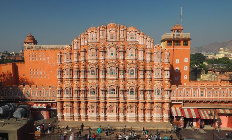 A large building in light pink with lots of windows - the building is shaped like a tiara.