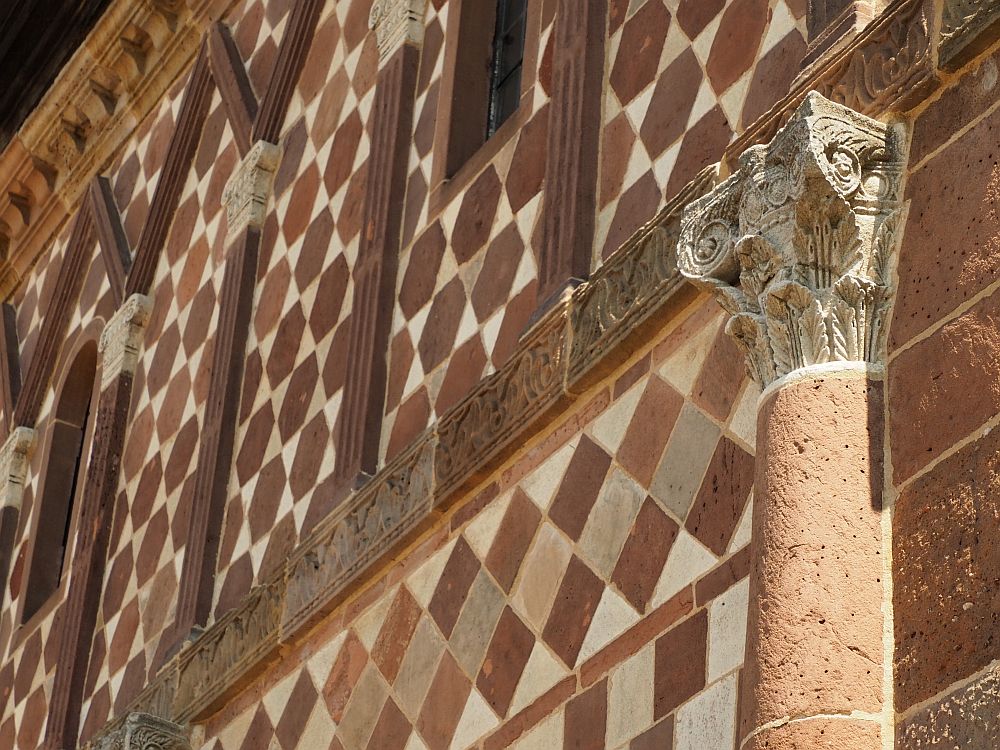 This closeup of a section of the Lorsch gatehouse shows the intricacy of the facade: Some of the bricks are square in a red and white checkerboard pattern, but some of them are actually 6-sided red stone, with white stone between them. One pillar shows in this photo too: half-cylindrical with half a corinthian capital.