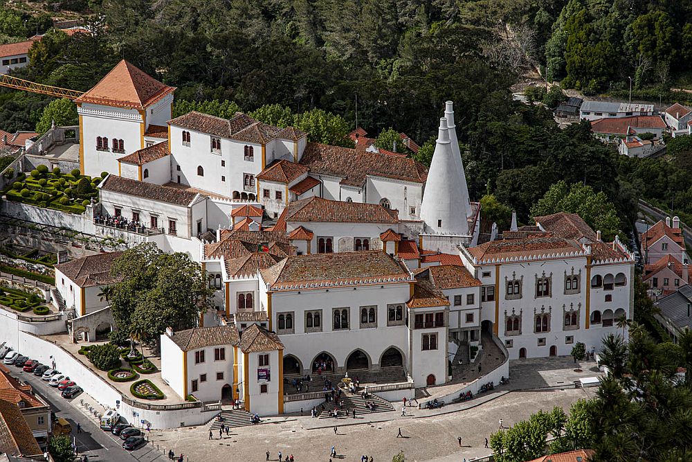 Seen from above, the palace is a whole complex of buildings, mostly 2-3 stories high, in white plaster with red roof tiles. There are two white conical towers on one of the buildings.