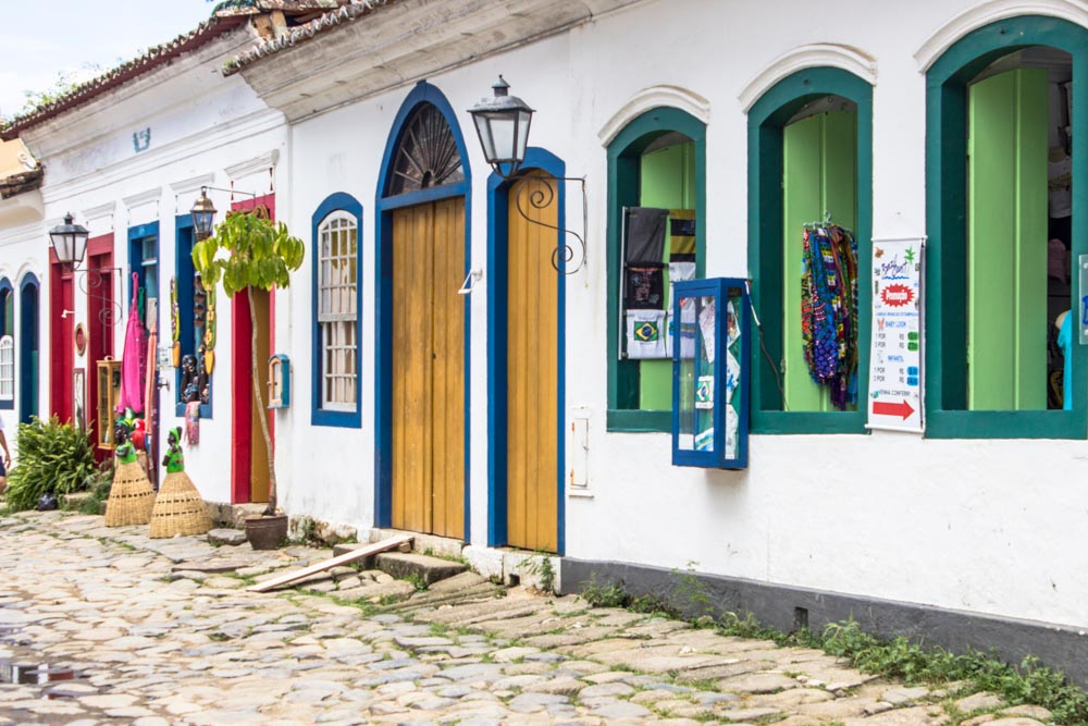 A pretty row of single story houses: all painted white but with bright paint of various colors around windows and doors.