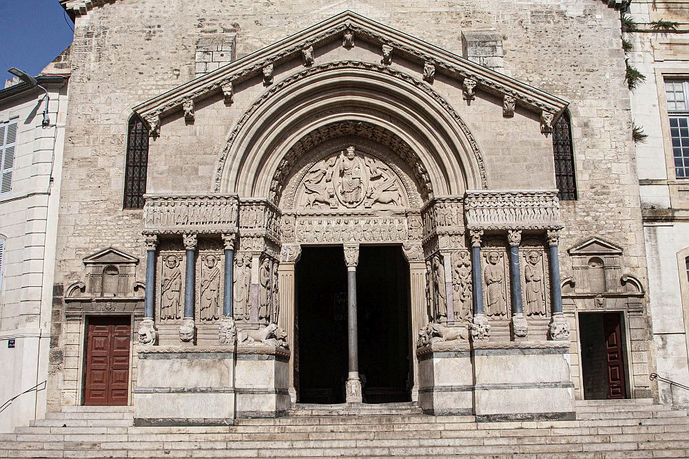 The Church of St. Trophime in Arles has a Romanesque entranceway, shown in this photo. Rounded arches above a double door, pillars on each side of the door.