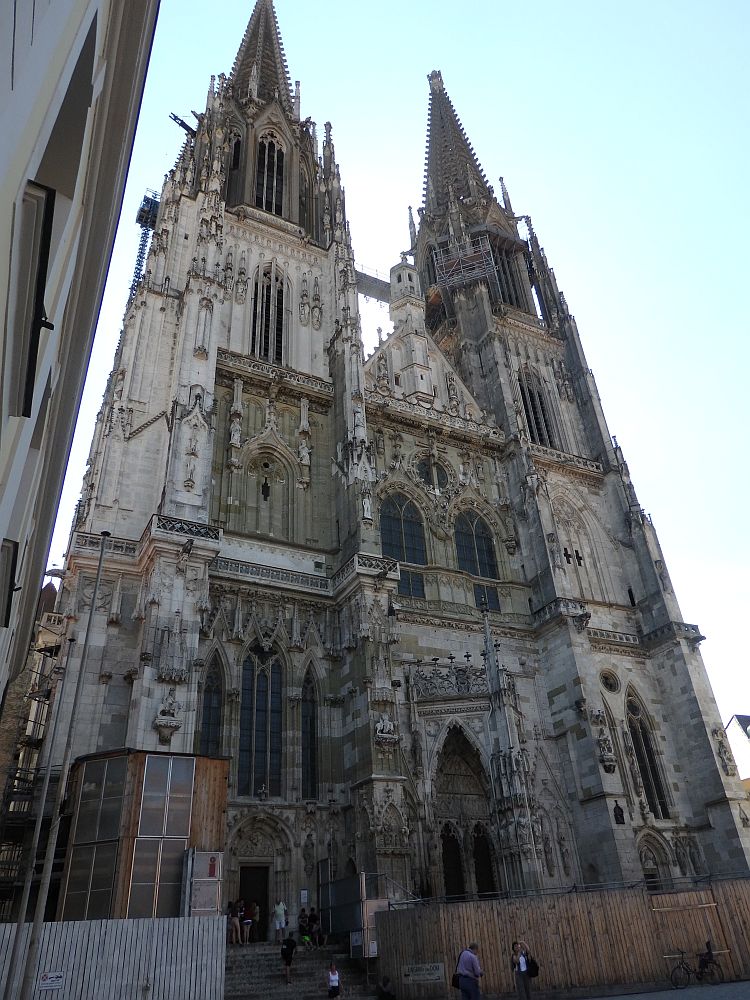 Front of the Gothic cathedral in Regensburg, Germany: 2 spires, the entrance under the left-hand spire. Much gothic detail.