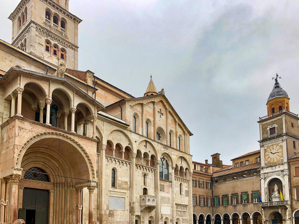 The front of the cathedral in Modena, with typical Romanesque rounded arches above the entry door and upper windows.