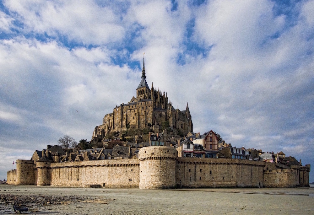 From this angle, taken at low tide, the fortification walls at the bottom seems to stand on sand, round towers at each corner. Above rise the Gothic walls and spires of the church.