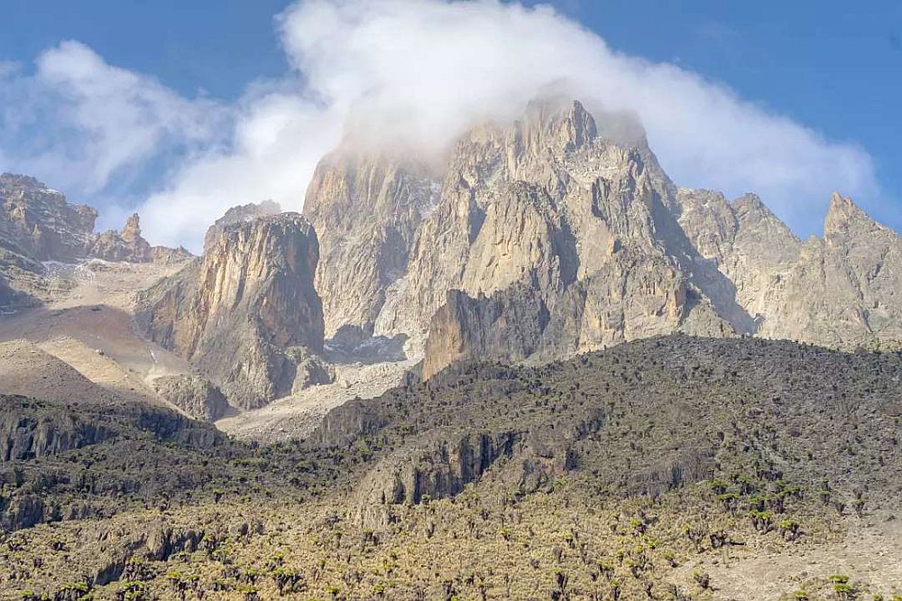 Mount Kenya: A mountain peak, rocky and steep, with clouds around its top.