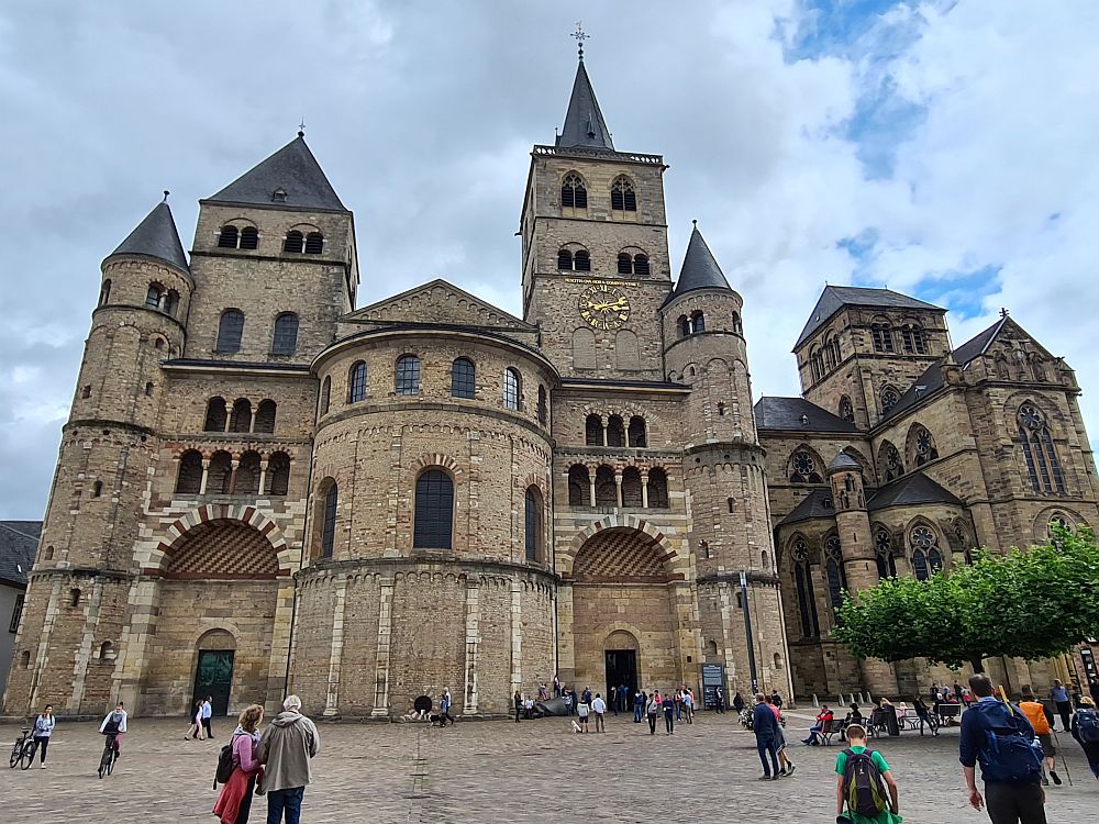 Romanesque church on the left with rounded arches over the two entrances, two towers of different sizes. Gothic church on the right with gothic (pointed) arches over the windows.