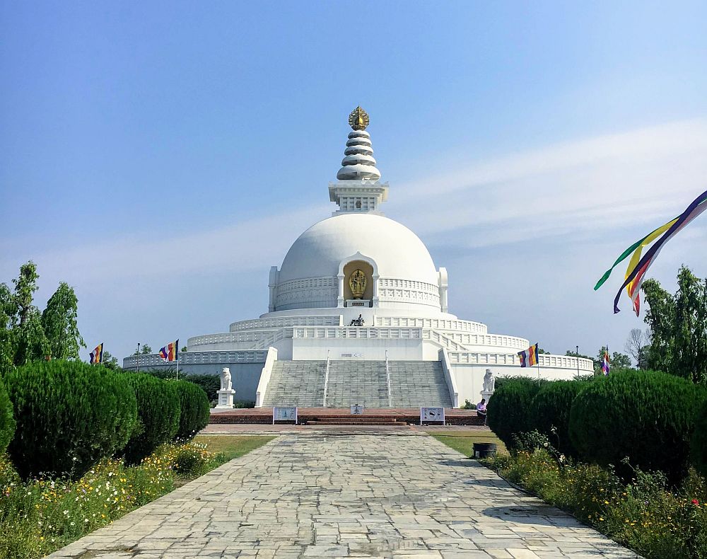In Lumbini, Nepal, a round structure, entirely white, with a semi-spherical dome in its center, and a conical pagoda on top of that.