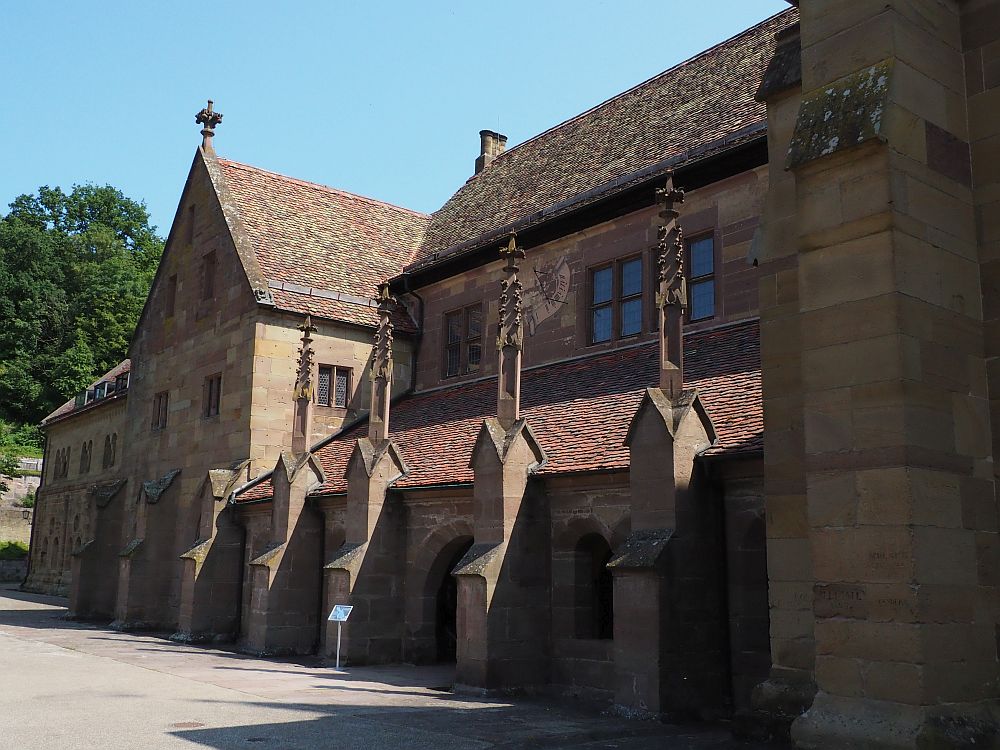 The exterior of the church at Maulbronn is a rather simple stone building, but with a single story side hall that extends out from the taller central portion of the church. This photo looks along that side: buttresses between the arched windows, each with a decorative extension on its top.