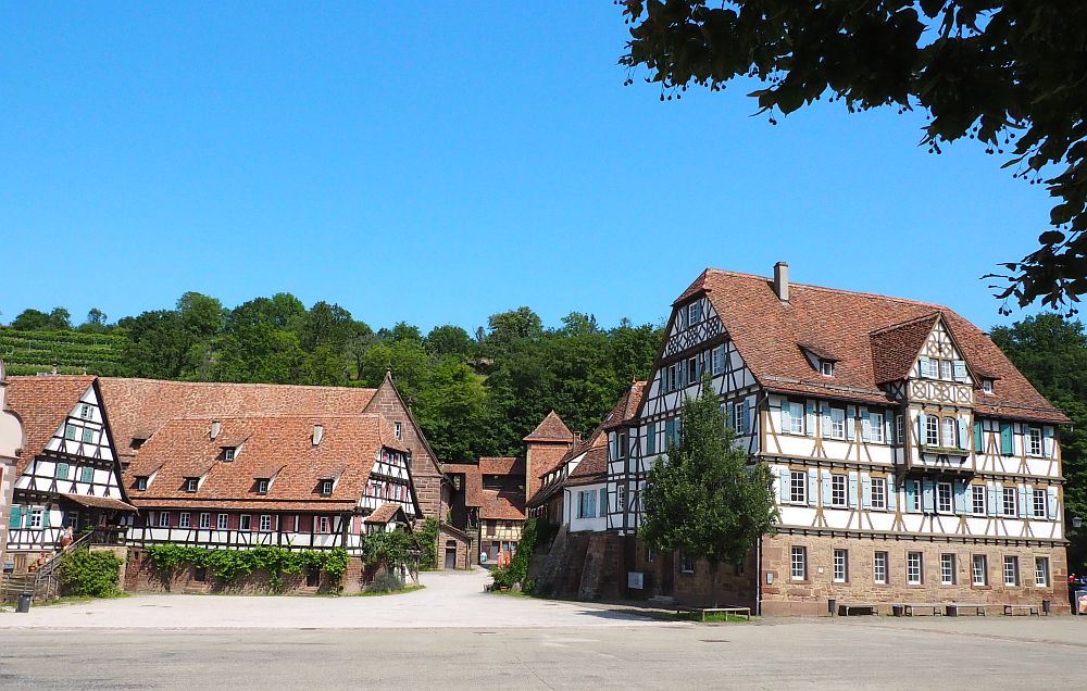 A cluster of half-timbered buildings on stone ground floors, each with three or four storeys above that.
