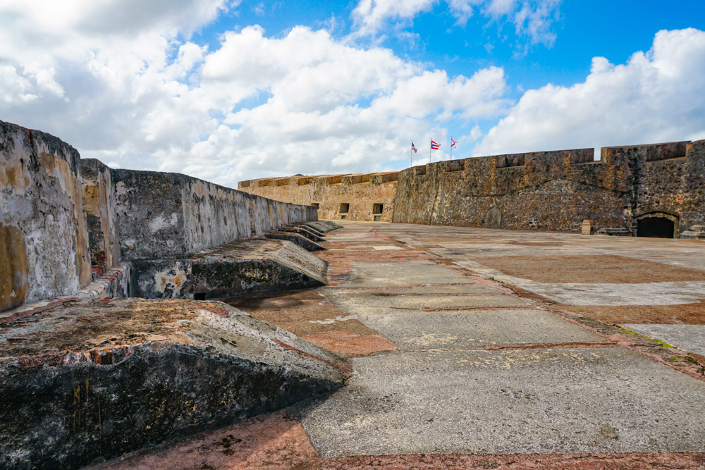 Atop Castillo San Cristobal: thick walls on either side, covered with lichen, and a flat, stone-paved space between the walls.