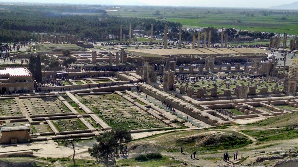 View from a height over the whole complex of Persepolis shows how large the site is, with ruins visible in the neat outlines of the remaining walls and columns.