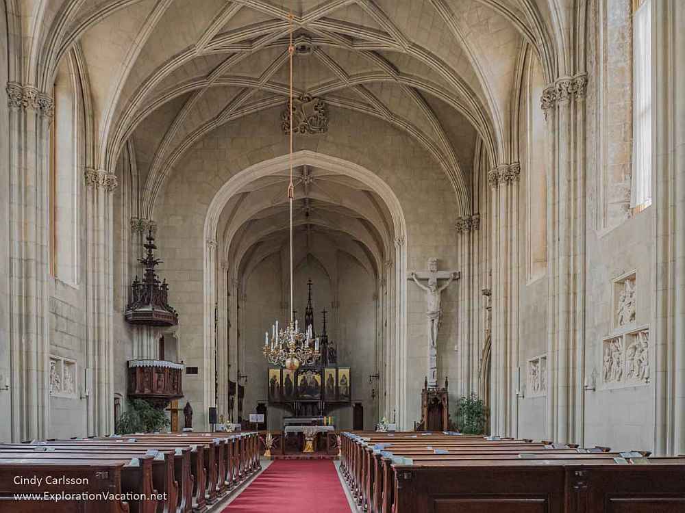 The inside of a neo-gothic church, facing the altar, gothic arches overhead.