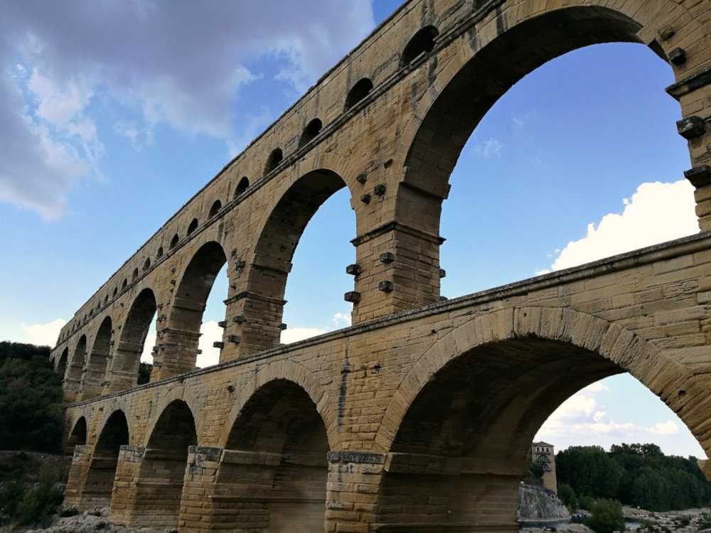 The Pont du Gard seen from the ground and to one side of the river: looking up at some of the rounded arches of the bottom and second levels. The bottom level is considerably thicker than the middle one.