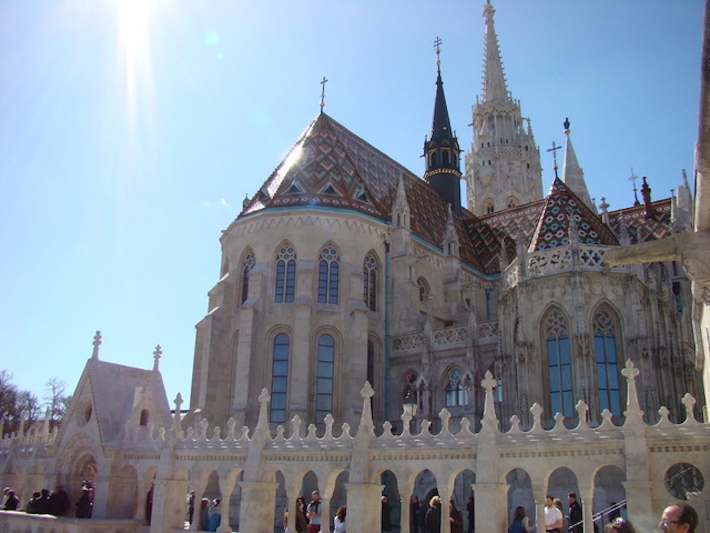 A gothic church in Budapest, with gothic arched windows, numerous small spires.