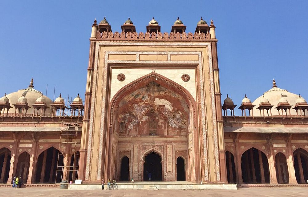 A grand gateway with decorative stonework around and inside the arched entryway at Fatehpur Sikri.