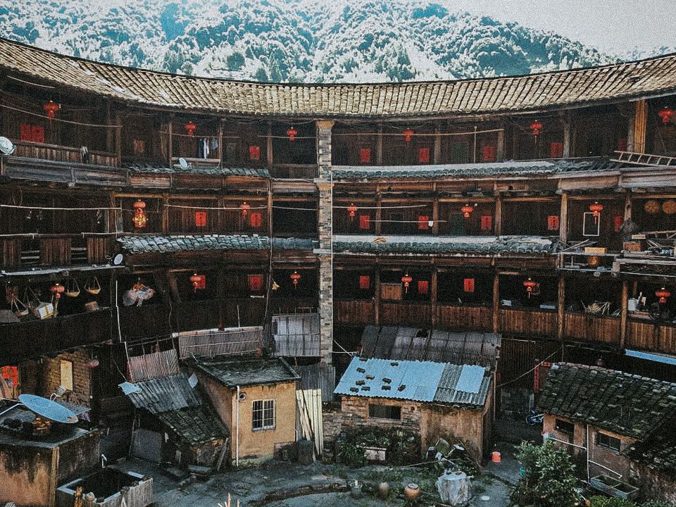 Inside of a tulou: 4 stories of apartments in a curved structure, i.e. they face into the center of the circle. On the ground are several small separate houses.