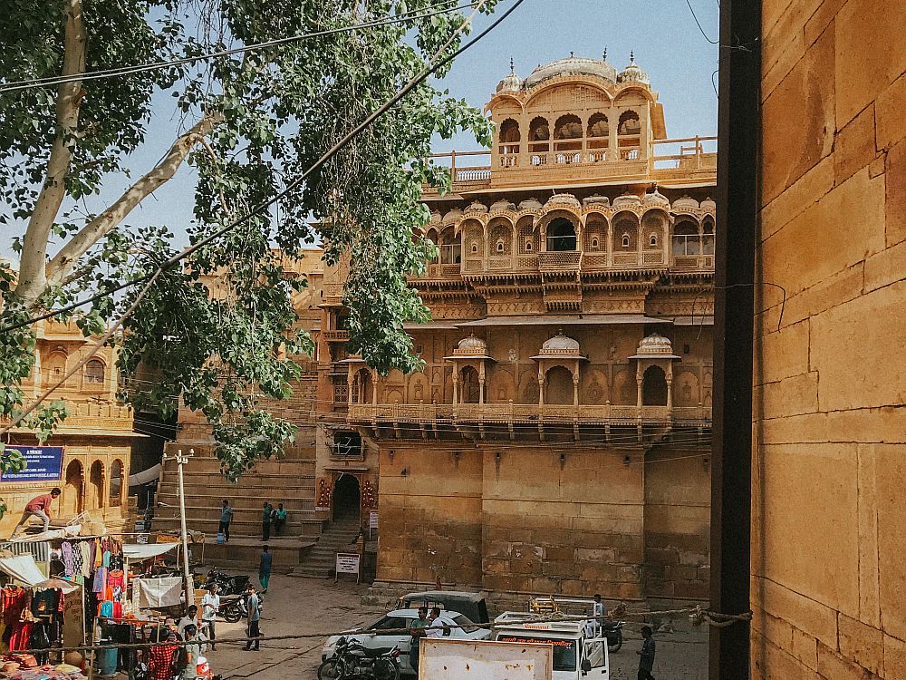 A small courtyard, with the palace on the far side: very ornate balconies with multiple arches, and a cupola on the roof, also with multiple arched windows.