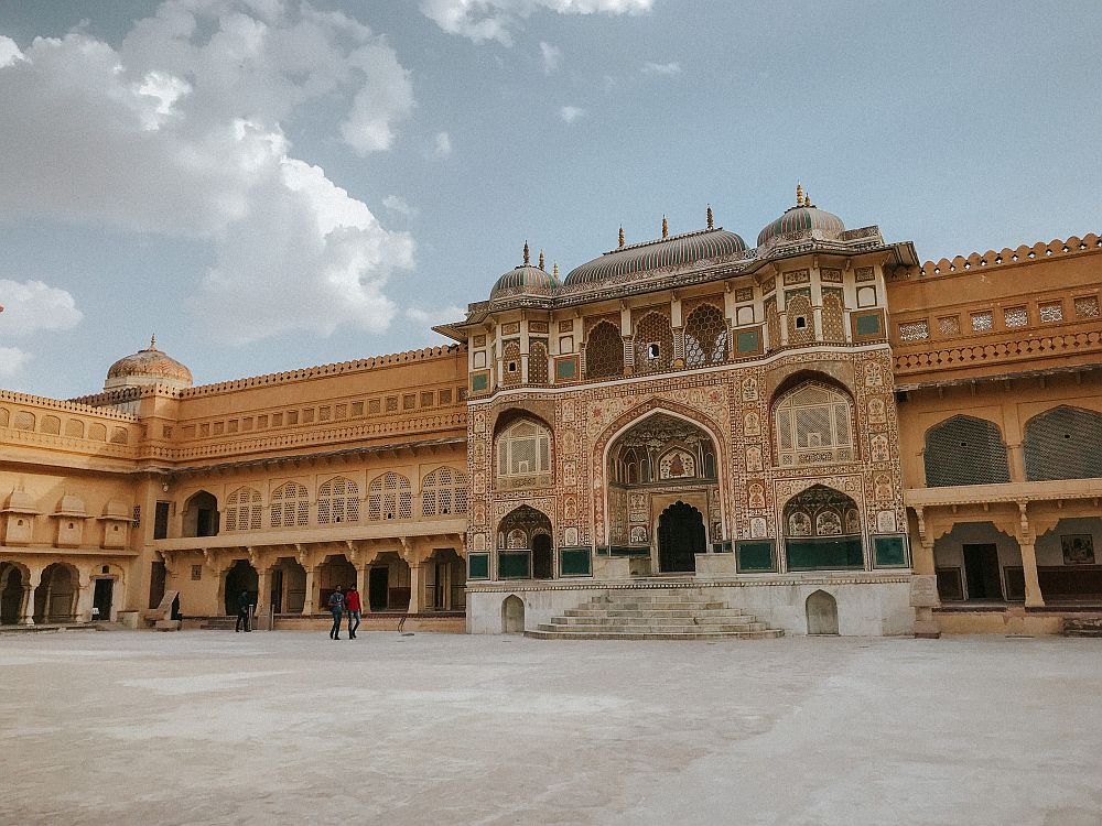 An ornate gateway in a building of 3-4 stories, decorated on every inch of the facade, which has multiple archways.