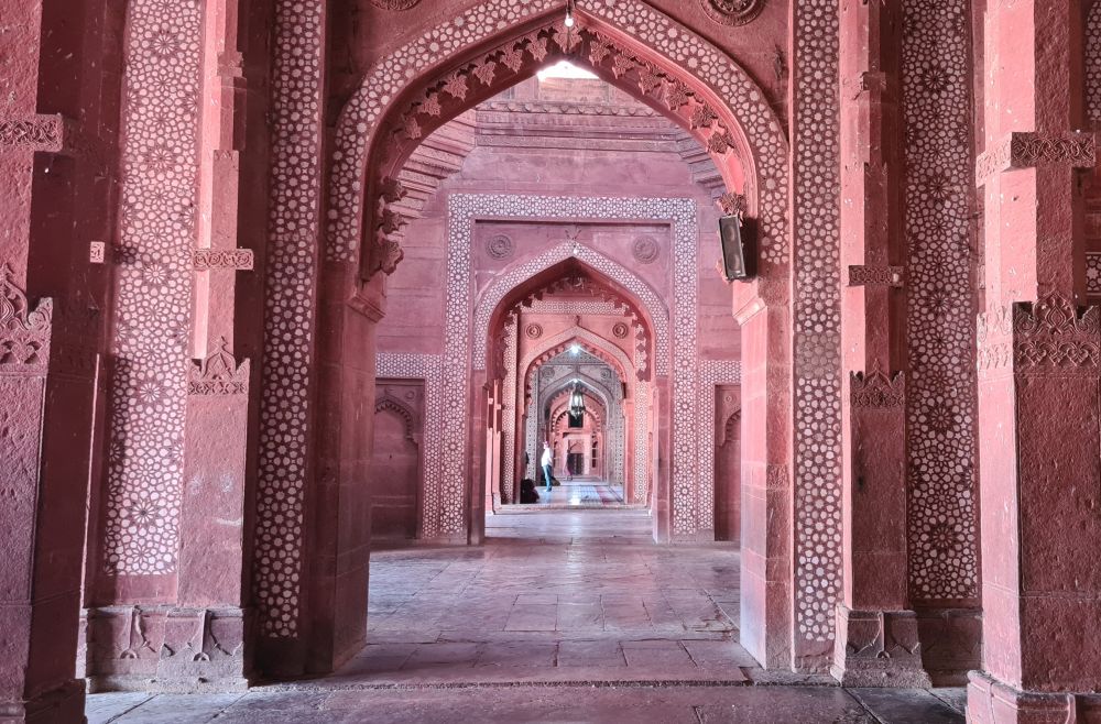 A view down a series of arches, all prettily carved in red sandstone.