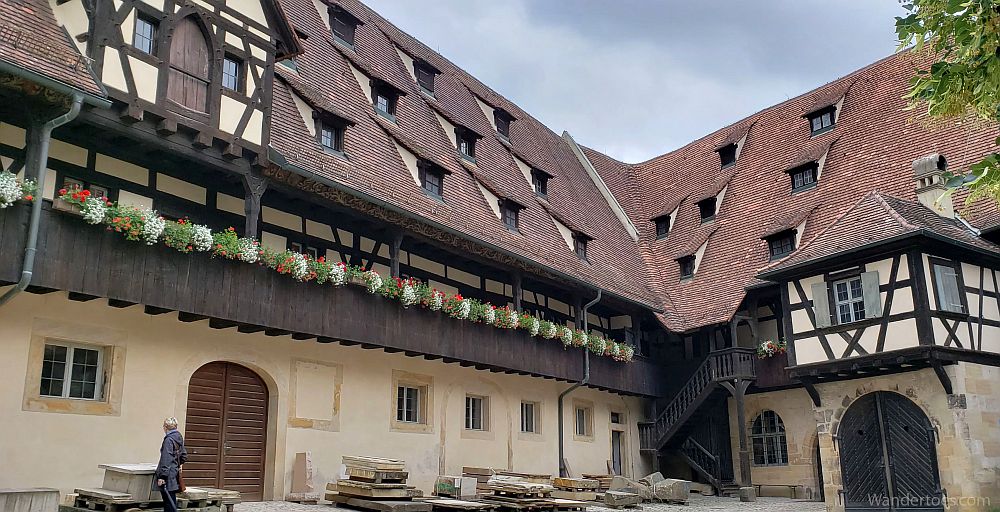 A medieval building with a steep roof with 3 stories under the roof, judging by the 3 rows of dormer windows. Below the eaves of the roof, 2 stories.