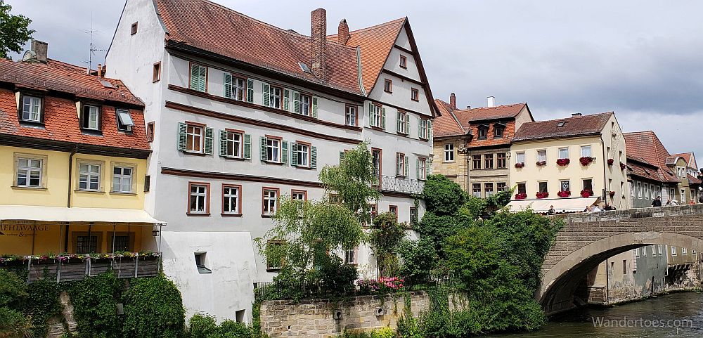 A row of pretty buildings, mostly 4-5 stories high, along a river in Bamberg, Germany