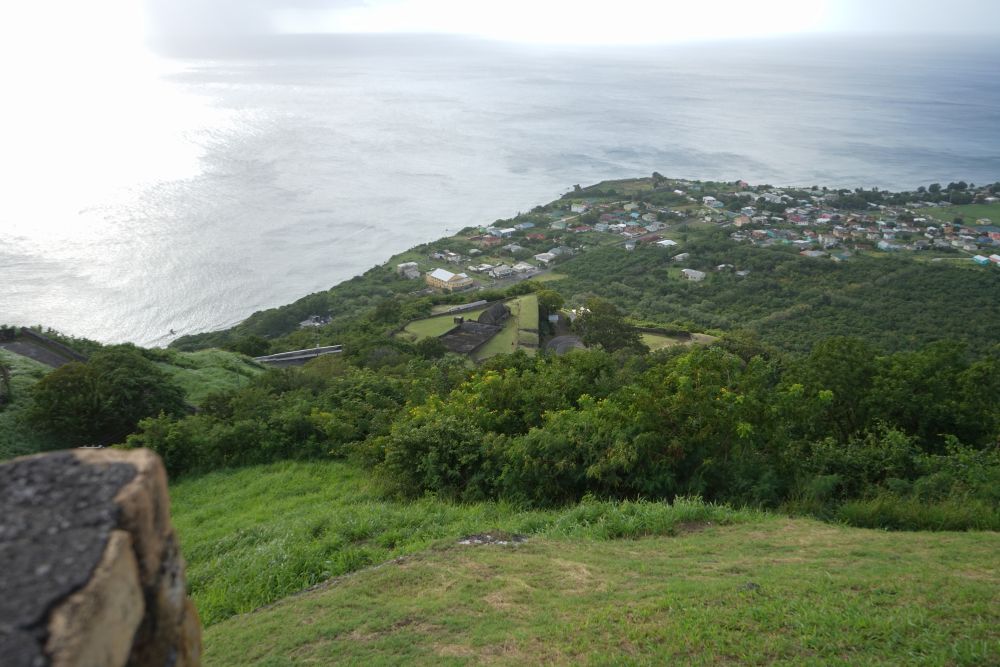 A view from Brimstone Hill Fortress, looking over a town far below and the sea beyond that.