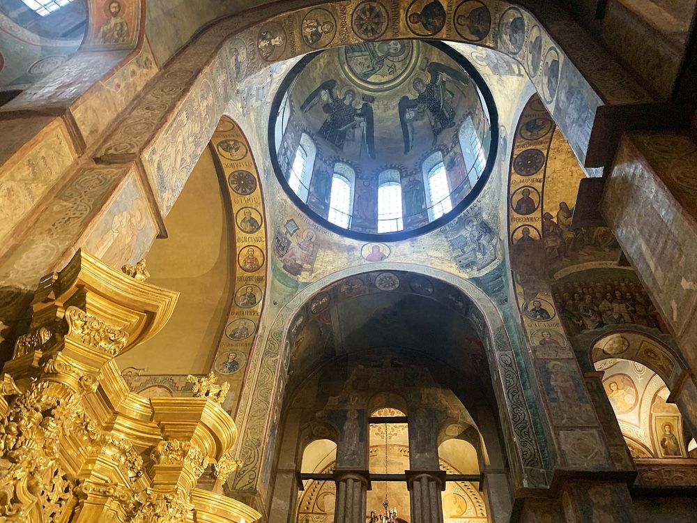 An ornately painted and very tall interior: images of saints, angels, etc. surrounded by gold.