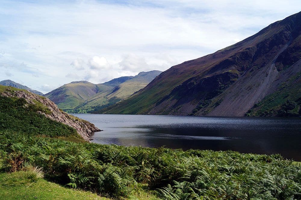 A view of a lake between green hills in the English Lake District