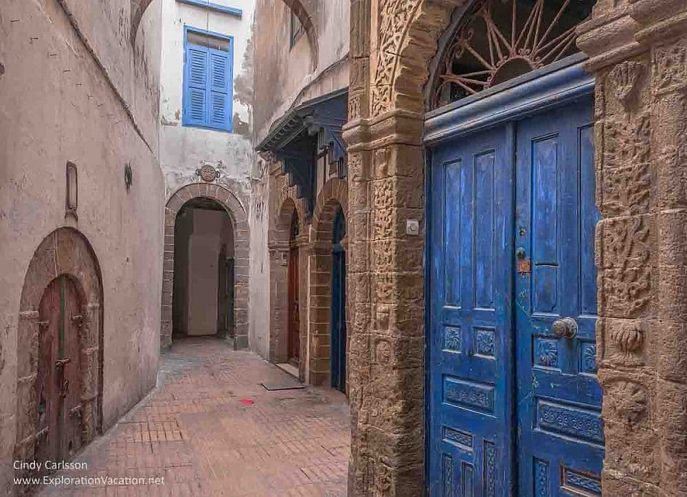 A street in Essaouira: narrow, with arched doorways, the nearest door painted blue.