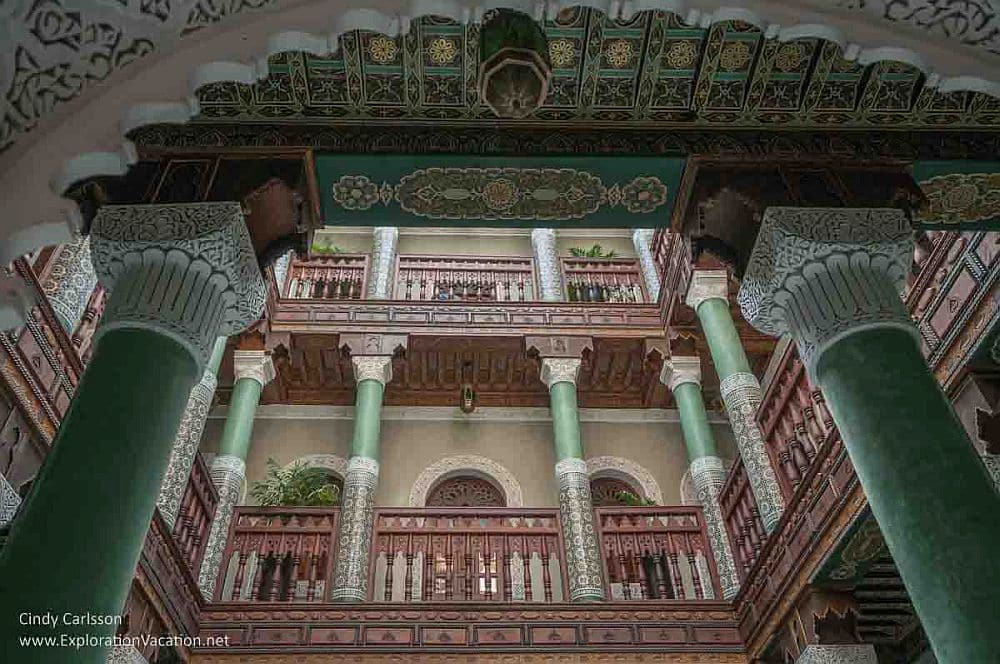 Looking up in a riad's courtyard in Essaouira: columns and decorative balcony railings.