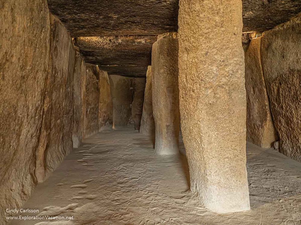 A room with large slabs of upright stones for walls and a series of slabs as columns down the center. The ceiling is more slabs of stone resting on the walls and columns.