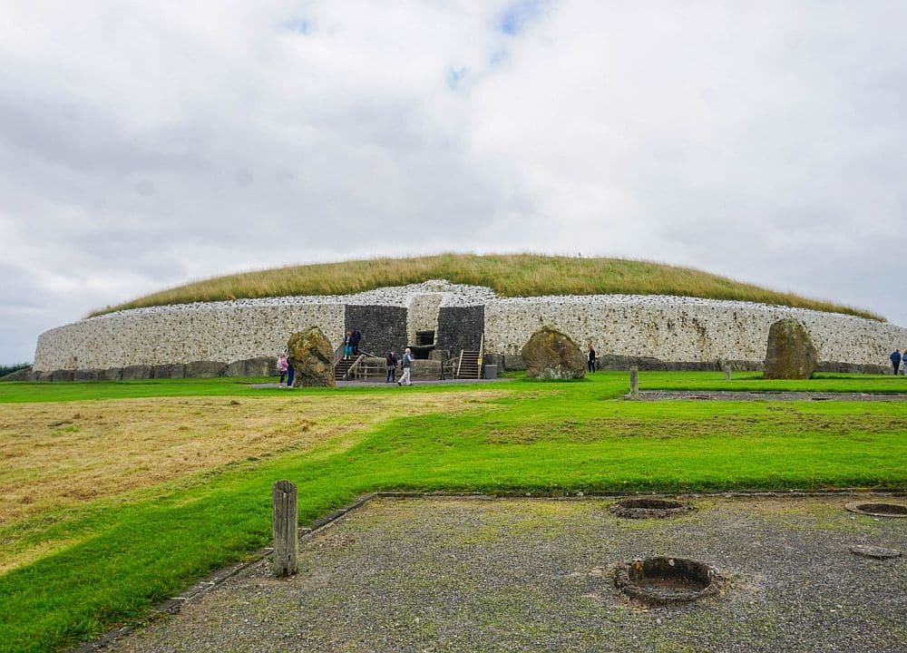 An extremely large burial mound with 2 entrances in the middle. The sides are a story tall and in a round shape, the top is grass-covered and dome-shaped.