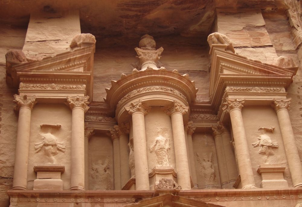 Decorative details show 3 "towers" cut from the cliff, though they're all still attached at the back. Decorated with corinthian capitals and human (or god) figures between pillars.