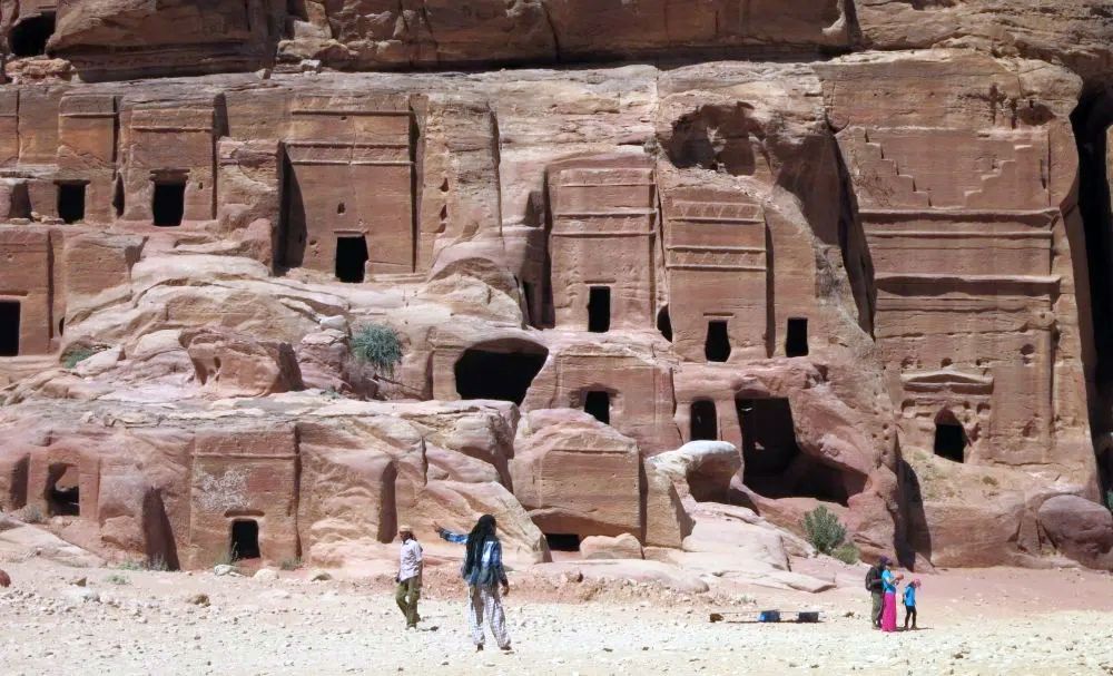 Tombs cut into a cliff: several stories tall, with just a doorway in each, and decorative carving around doors and top of each.