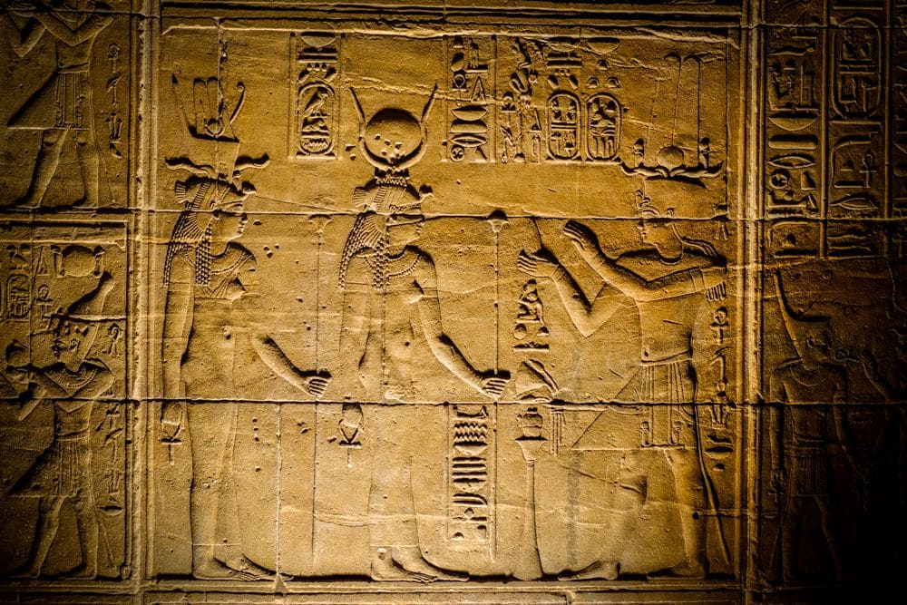 A bas-relief from inside Philae temple shows 3 figures of gods perhaps, or humans, with hieroglyphs around them.