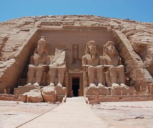 Four huge sitting statues, with a doorway - about 3x higher than a person and reaching to knee height on the statues - in the center. At Ramses Temple, Nubian Monuments