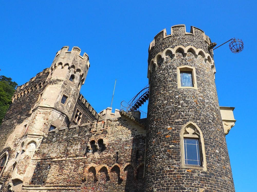 A medieval-looking castle: stone walls, crenellations around the tops of round towers at the corners.