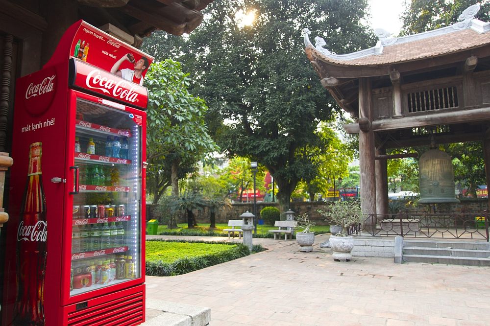 On the left, a modern vending machine. On the right, a building with the traditional curved roof. 