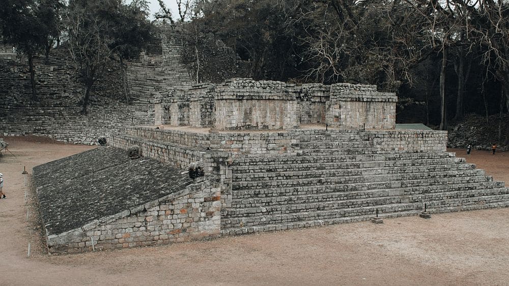 A stone temple, with wide stairs up the side and the remains of columns on top.