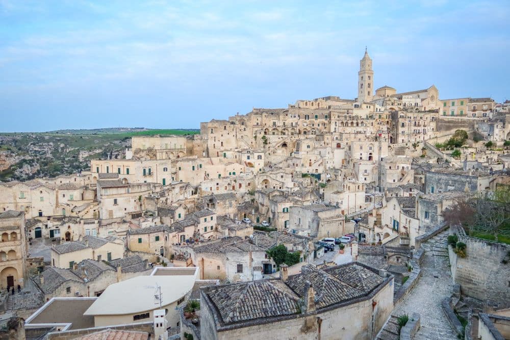 A view of the city of Matera showing clusters of dwellings on a hill.