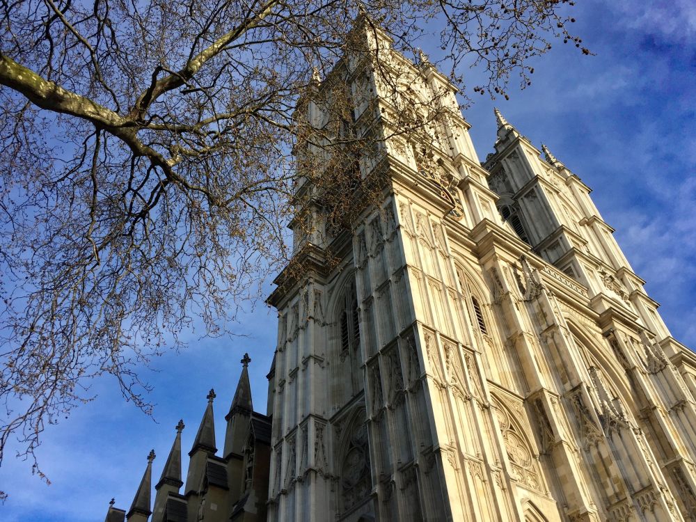Looking up at the front facade of Westminster Abbey with its two square towers.