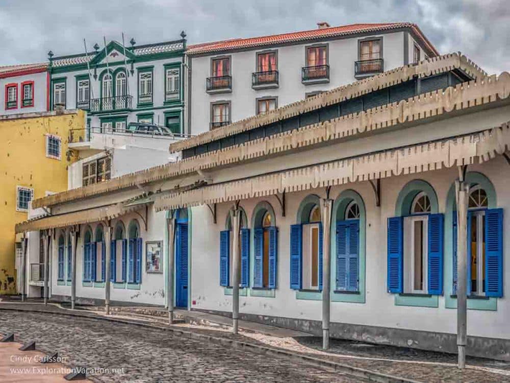 A prettily-painted row of buildings: white with bright color trim around the windows in Angra do Heroismo